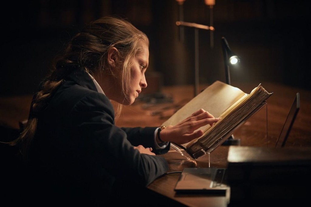 Diana Bishop (Teresa Palmer) étudie un vieux livre à la bibliothèque