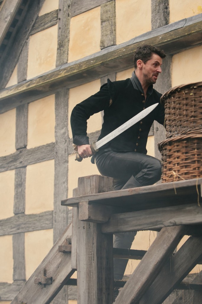 Matthew (Matthew Goode) épée à la main, tente d'échapper à Philippe en allant dans la grange