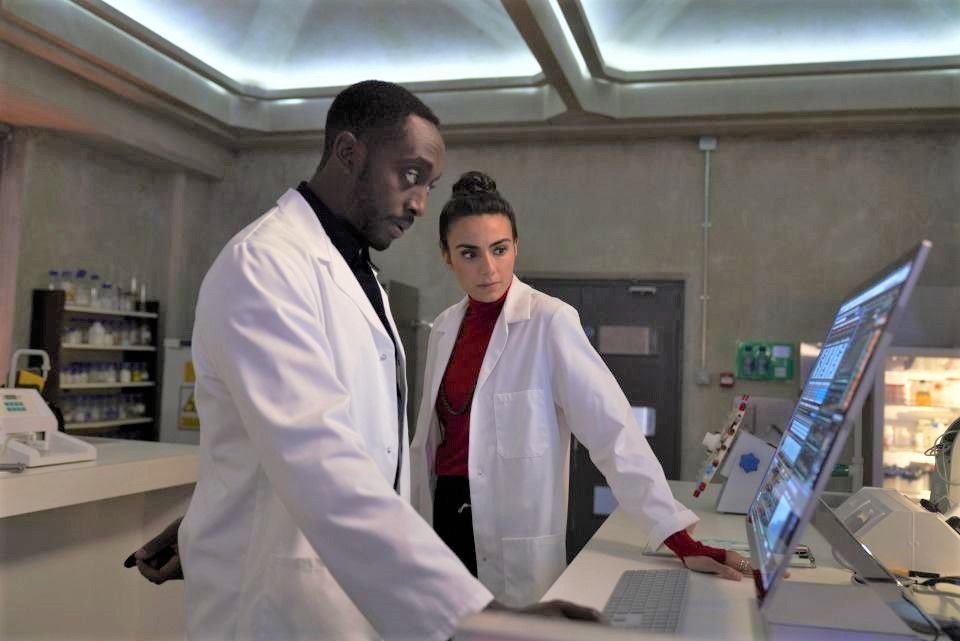 Chris (Ivanno Jeremia) et Miriam (Aiysha Hart) travaillent en étroite collaboration au laboratoire