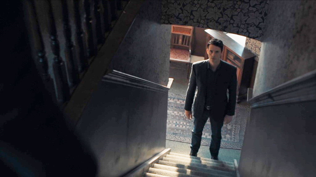 Matthew en bas des escaliers qui mènent à son appartement 