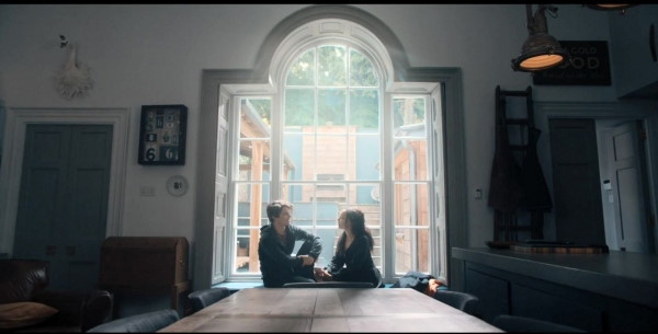 Marcus et Phoebe assis dans la cuisine près de la fenêtre